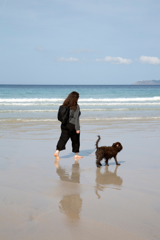 Woman and Dog on Beach in Galicia; Spain